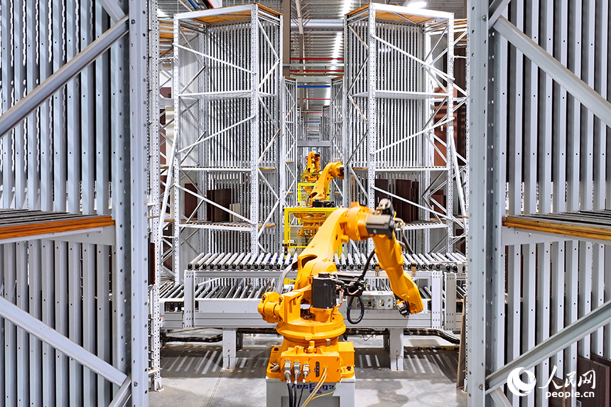 智能制造企業車間內，智能機器人手臂快速運轉，板材分揀包裝有序進行。人民網 朱海鵬攝