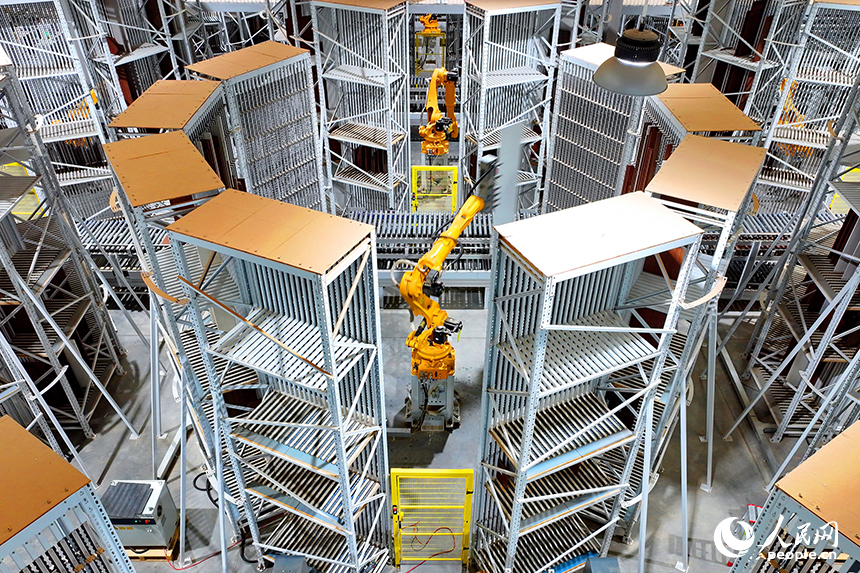 智能制造企業車間內，智能機器人手臂快速運轉，板材分揀包裝有序進行。人民網 朱海鵬攝