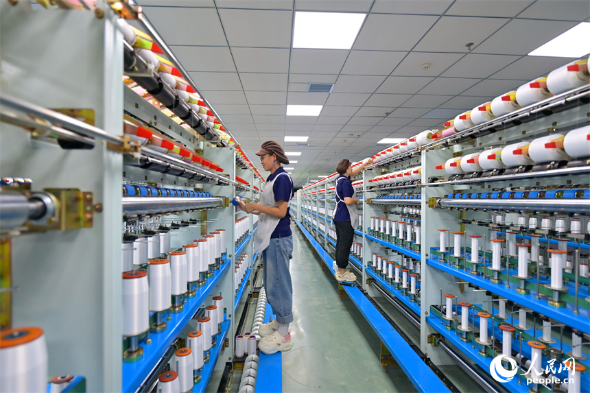 江西申華新材料有限公司5G智慧車間內，工人在加工錦綸紡絲新材料產品。人民網 朱海鵬攝