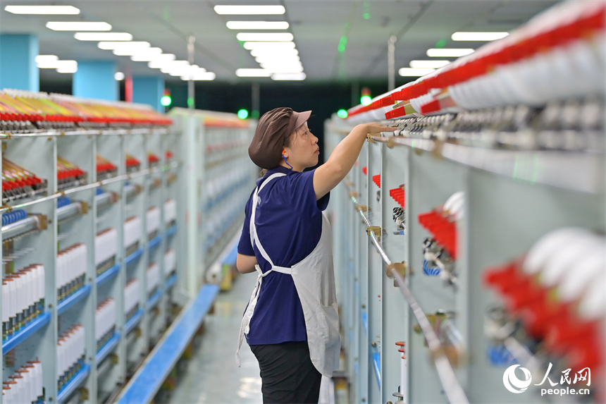 江西申華新材料有限公司5G智慧車間內，工人在加工錦綸紡絲新材料產品。人民網 朱海鵬攝