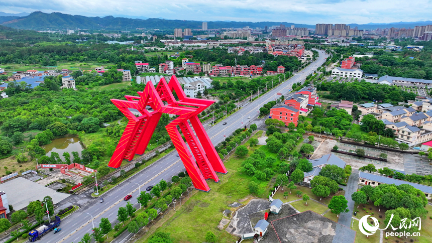 瑞金市葉坪鎮葉坪村，“勝利之門”地標蔚為壯觀，周邊鱗次櫛比的房屋與郁郁蔥蔥的田園、山丘、樹木相映成景。人民網 朱海鵬攝