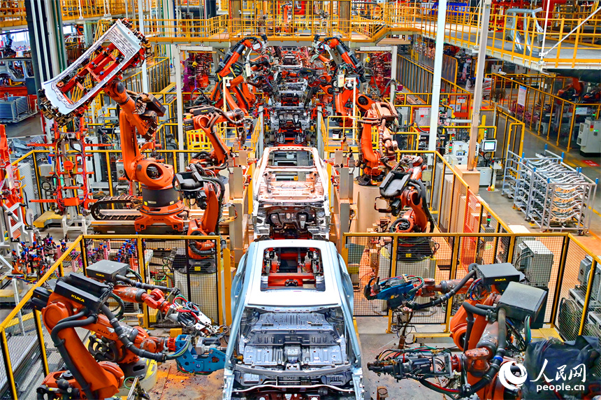 江鈴汽車富山工廠數字化車間內，智能焊裝機械臂有序運轉，工人在生產線上忙碌。人民網 朱海鵬攝