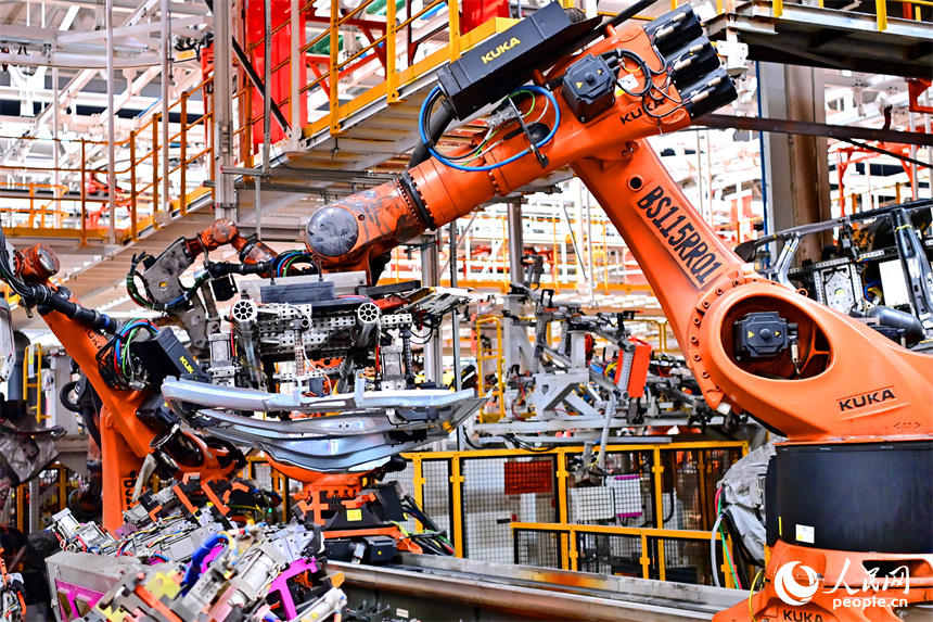 江鈴汽車富山工廠數字化車間內，智能焊裝機械臂有序運轉，工人在生產線上忙碌。人民網 朱海鵬攝