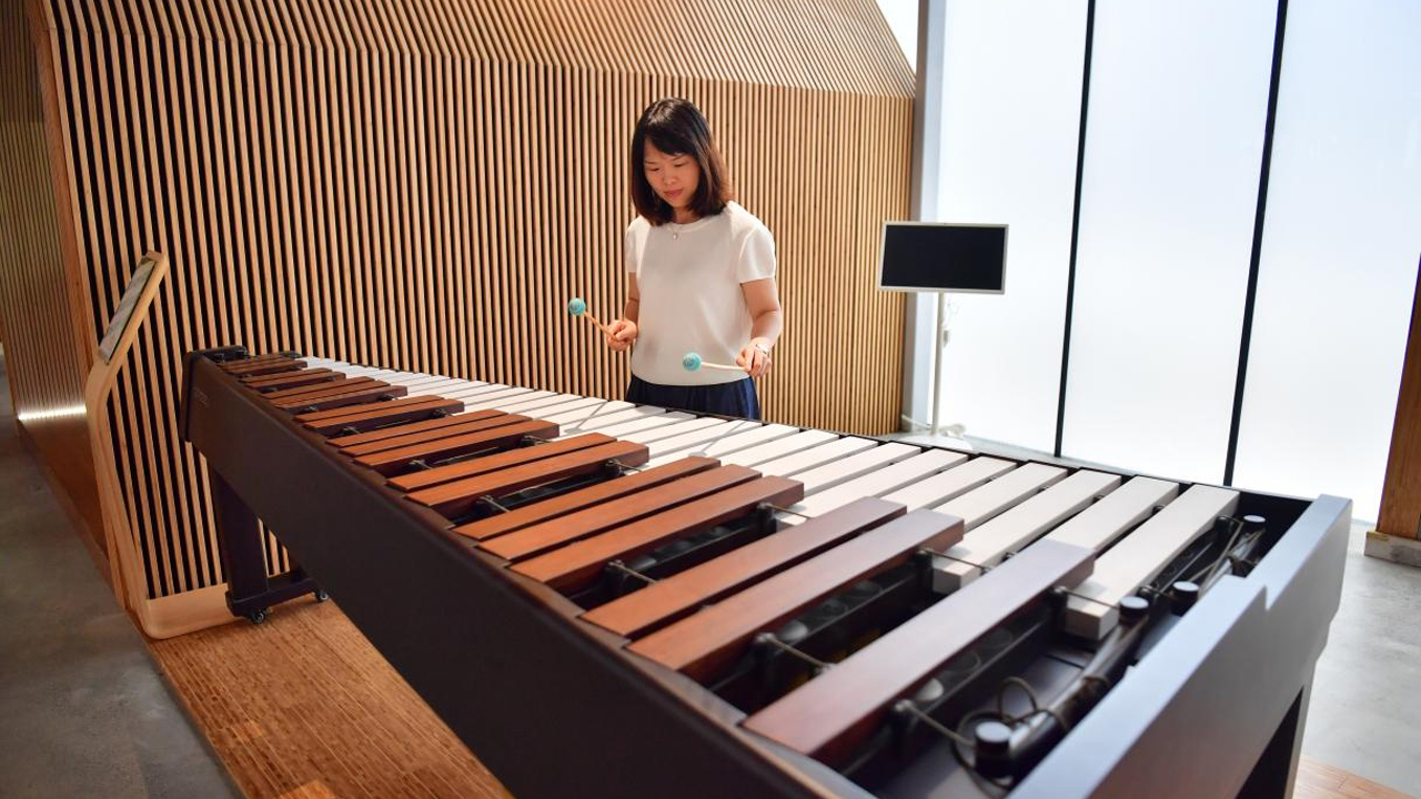 記者正在體驗彈奏竹管琴