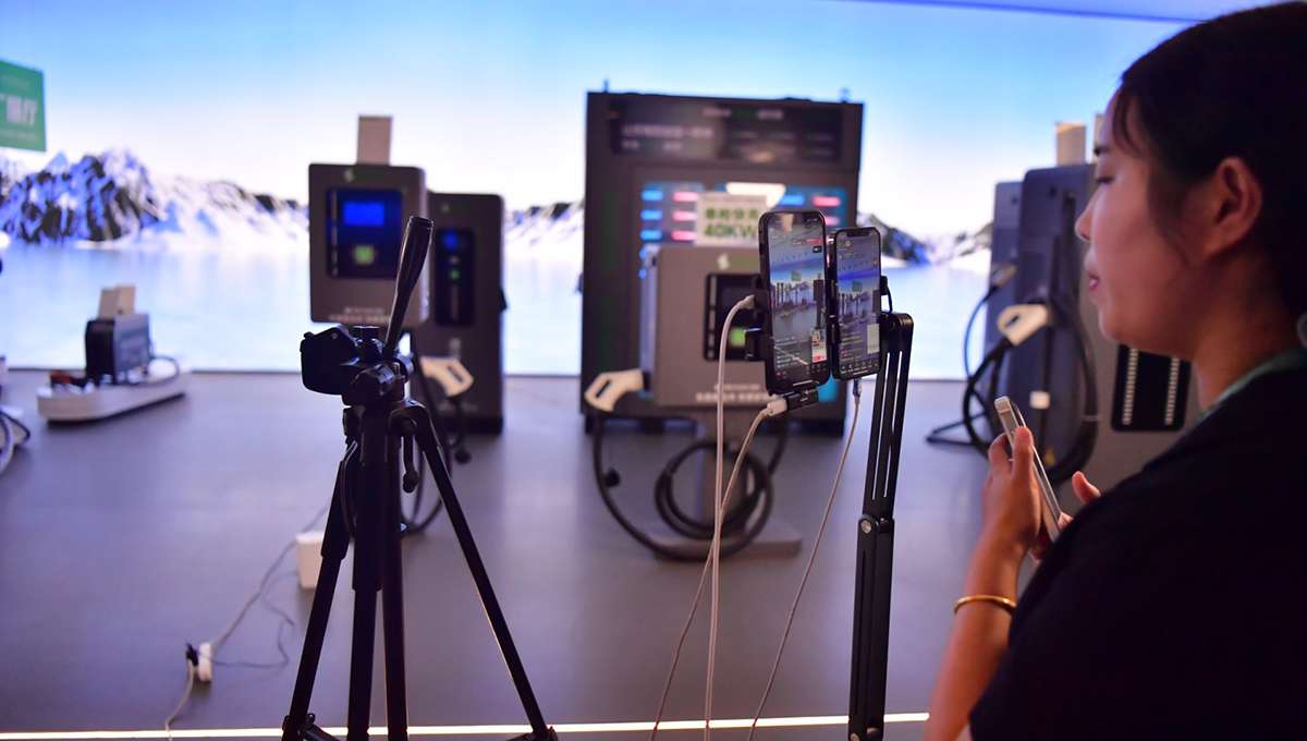 贛州章貢區江西驢充充物聯網科技有限公司內，主播正在直播鏡頭前介紹充電設備。