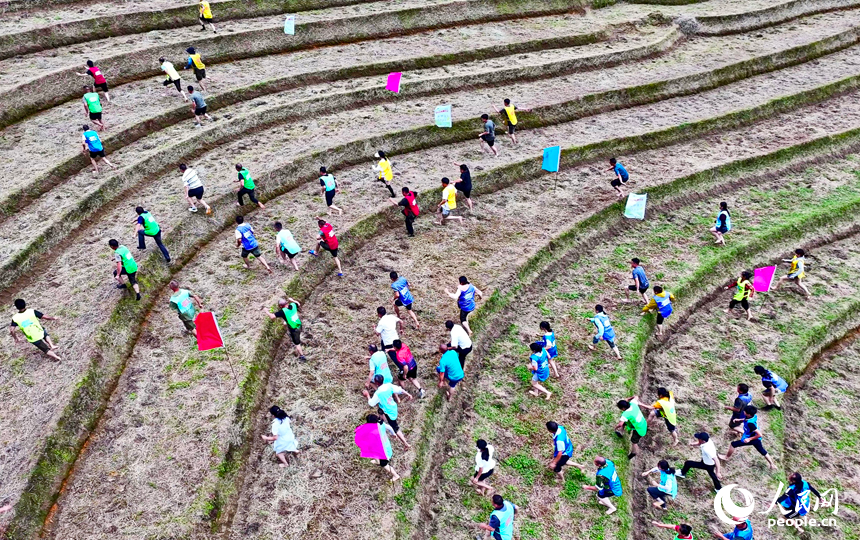 崇義縣上堡鄉上堡梯田，村民在參與鄉村趣味運動會梯田攀爬比賽。人民網 朱海鵬攝