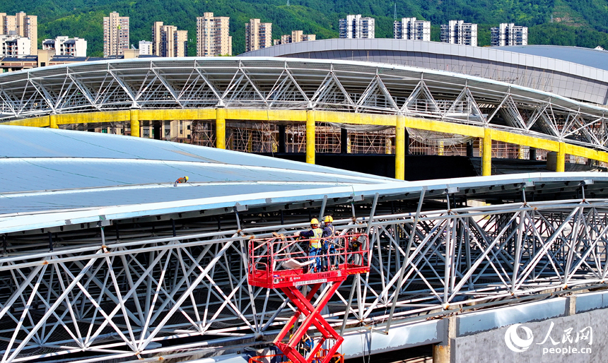 贛州市石城縣西城體育中心項目建設現場，工人在安裝體育館鋼結構屋面網架和頂棚。人民網 朱海鵬攝