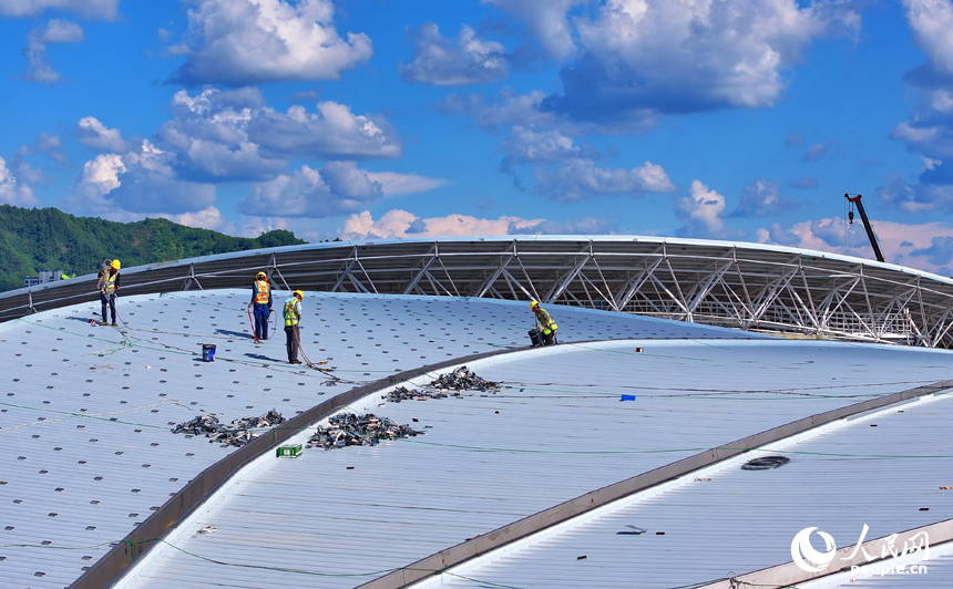 贛州市石城縣西城體育中心項目建設現場，工人在安裝體育館鋼結構屋面網架和頂棚。人民網 朱海鵬攝
