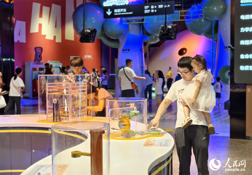 一位家長帶著孩子做科學小實驗。人民網記者 時雨攝