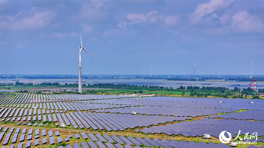 九江市彭澤縣帽子山風光電站，連片的光伏發電板與風力發電機組相得益彰，源源不斷地輸送清潔能源。人民網 朱海鵬攝