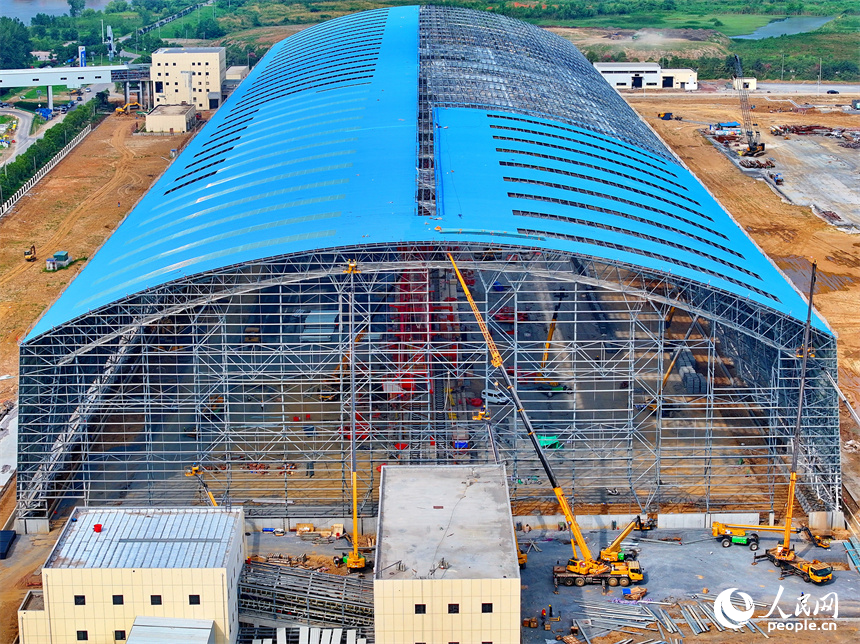 建設者們冒著高溫在高空進行貨棚擋板安裝作業。人民網 朱海鵬攝