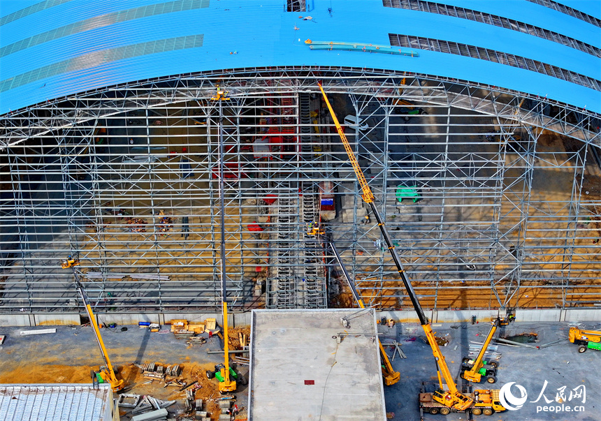 建設者們冒著高溫在高空進行貨棚擋板安裝作業。人民網 朱海鵬攝