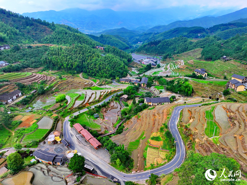 贛州市崇義縣上堡鄉上堡梯田，層層疊疊的梯田與漫山竹木、錯落民居、蜿蜒公路相互映襯。人民網 朱海鵬攝