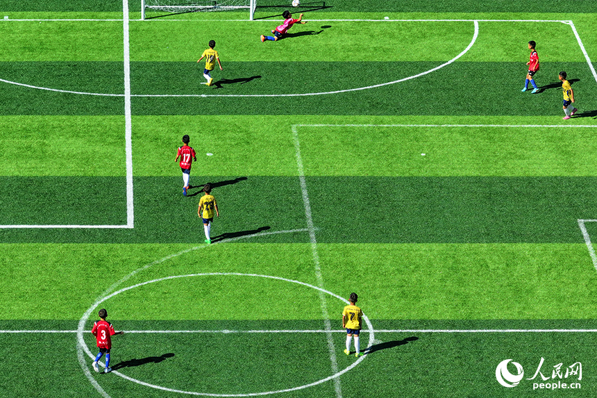 江西定南（國家）青少年足球訓練中心，各地前來參加夏季訓練營的足球小將們在場上訓練、比賽。人民網 朱海鵬攝