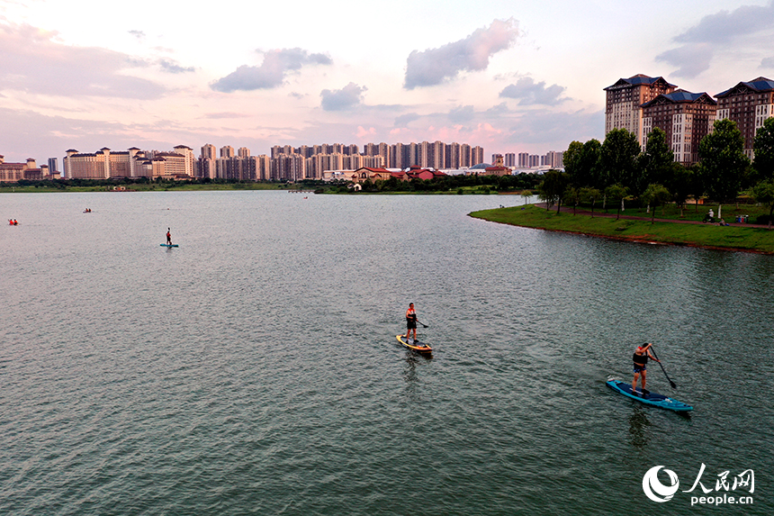 夕陽下，紅谷灘區九龍湖泛著金色波光，槳板愛好者們正在湖面揮槳劃行。人民網記者 時雨攝