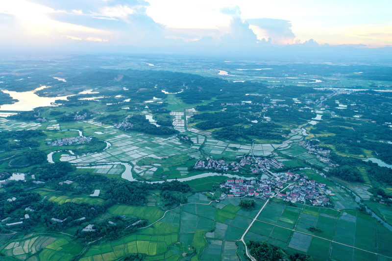 上高縣新界埠鎮五星村，夕陽與田壟、公路、民居、河流構成一幅田園風光畫。陳旗海攝