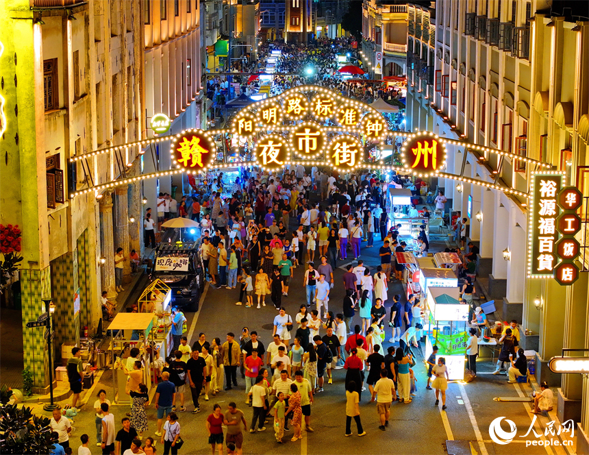 贛州市陽明路標準鐘夜市街，人頭攢動、熙熙攘攘，許多游客在逛夜市、吃小吃。人民網 朱海鵬攝