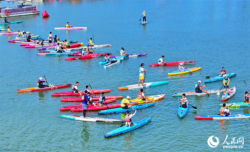 贛州市崇義縣過埠鎮的贛州小漓江，許多槳板運動愛好者在水上劃行競技。人民網 朱海鵬攝