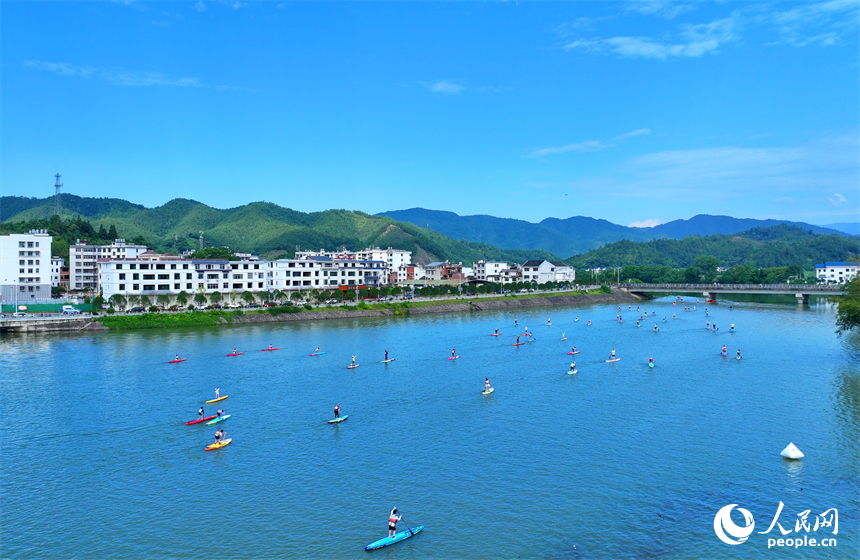 贛州市崇義縣過埠鎮的贛州小漓江，許多槳板運動愛好者在水上劃行競技。人民網 朱海鵬攝
