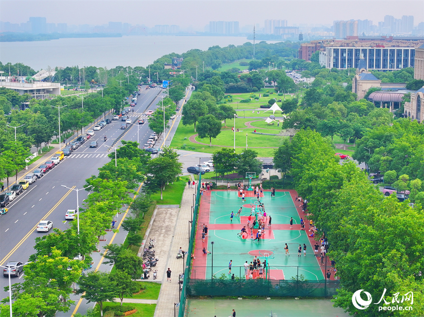 南昌高新區氣膜體育中心室外球場，市民在打網球、打籃球，享受運動健身的樂趣。人民網 朱海鵬攝
