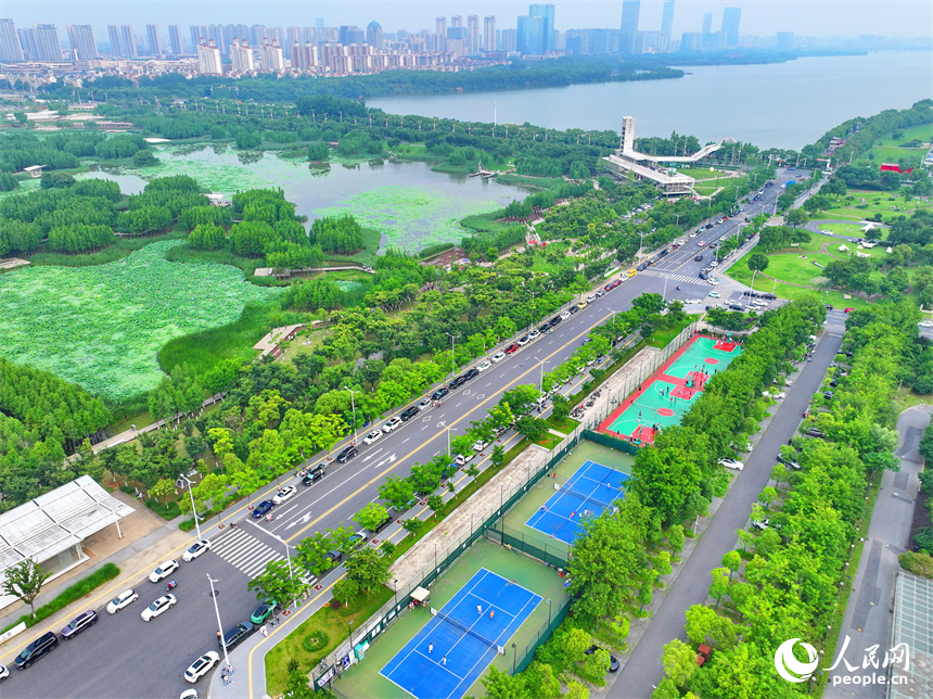 南昌高新區氣膜體育中心室外球場，市民在打網球、打籃球，享受運動健身的樂趣。人民網 朱海鵬攝