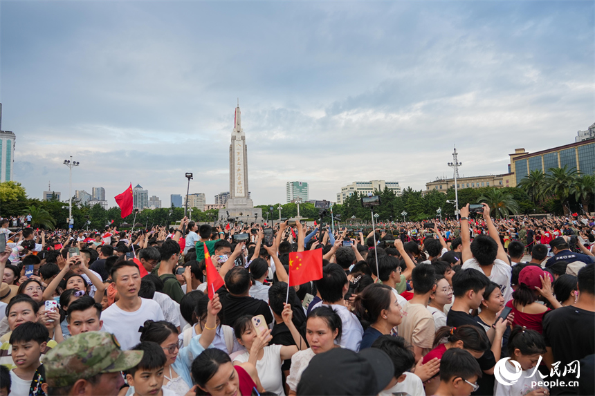 現場觀禮的市民游客紛紛拿起手機拍攝留念。人民網 涂詩軒攝