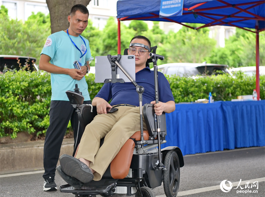 參觀者在科技助殘展區咨詢試用人工智能康復輔助器具產品。人民網 朱海鵬攝