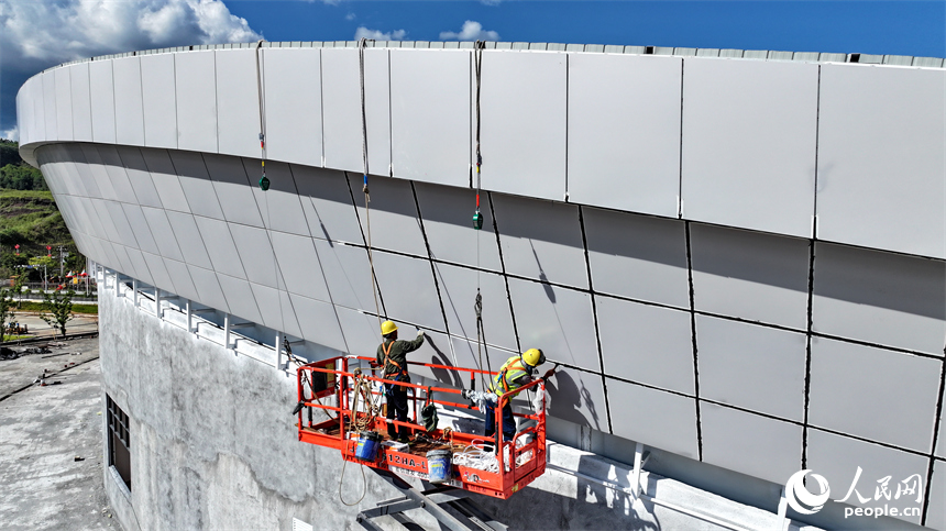 贛州市石城縣西城體育中心項目建設現場，工人冒著高溫在安裝體育場館外立面鋁板。人民網 朱海鵬攝