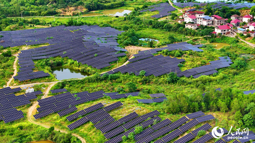 撫州市南豐縣萊溪鄉西山村“農光互補”光伏發電站，荒山坡上安裝的光伏板熠熠生輝，與綠樹青山相映相襯。人民網 朱海鵬攝