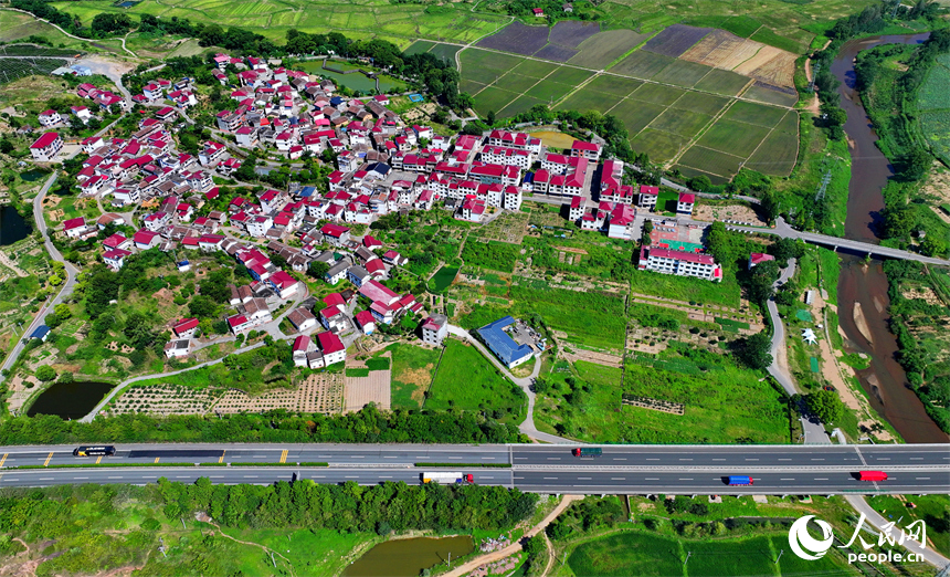 撫州市南豐縣萊溪鄉九聯村，白墻紅瓦的民居與綠色田園相互映襯，構成一幅宜居宜業和美鄉村畫卷。人民網 朱海鵬攝