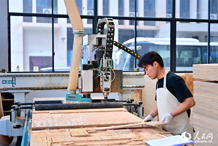 贛州市南康區的一家“工業上樓”項目家具生產企業內，工人在加工軟體家具。人民網 朱海鵬攝