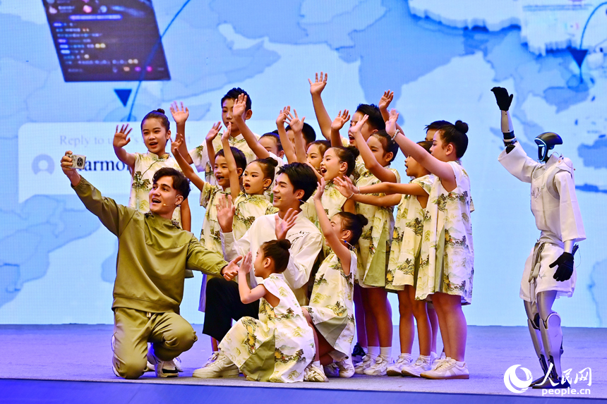 2025江西省網絡文明大會現場，人形機器人化身“詩人”，現場表演誦讀古詩詞，并與同臺表演者合影留念，讓觀眾耳目一新。人民網 朱海鵬攝