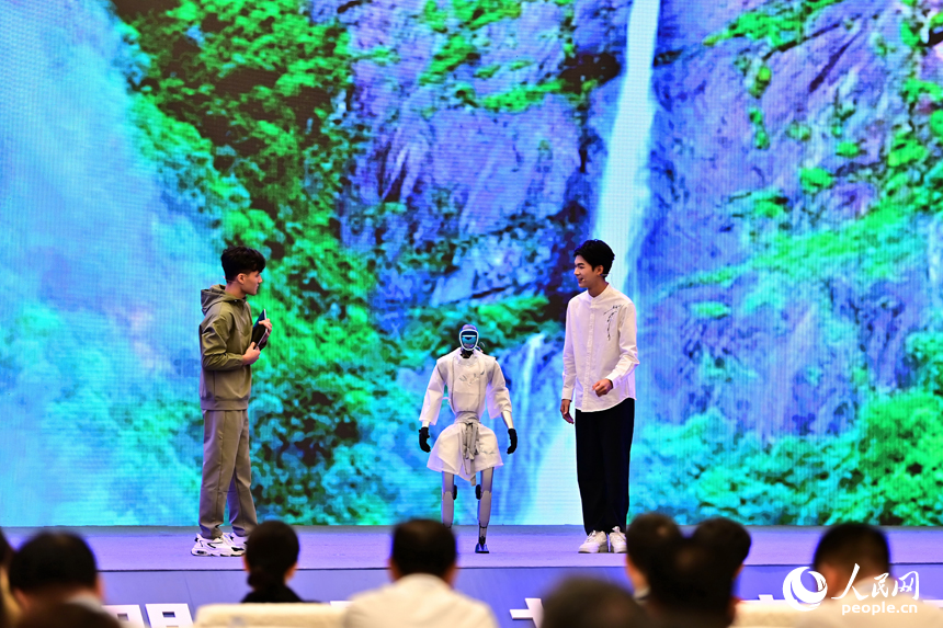 2025江西省網絡文明大會現場，人形機器人化身“詩人”，現場表演誦讀古詩詞，并與同臺表演者合影留念，讓觀眾耳目一新。人民網 朱海鵬攝