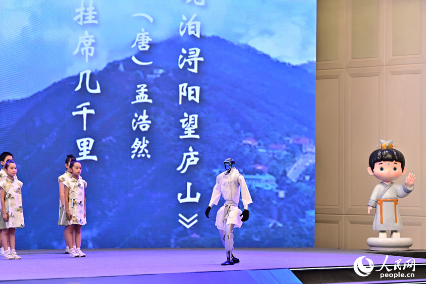 2025江西省網絡文明大會現場，人形機器人化身“詩人”，現場表演誦讀古詩詞，并與同臺表演者合影留念，讓觀眾耳目一新。人民網 朱海鵬攝
