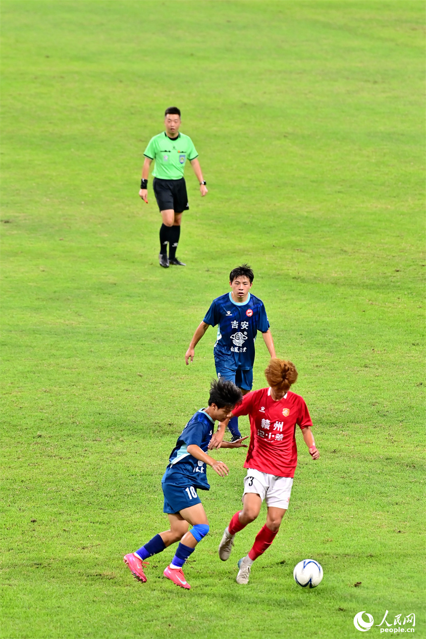 “贛超”第八輪比賽中，贛州隊球員與吉安隊球員在場上激烈拼搶。人民網 朱海鵬攝