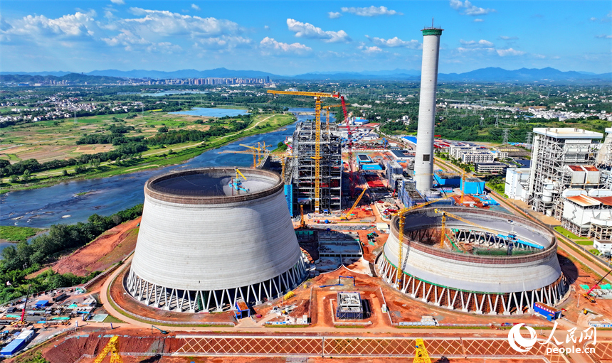 信豐電廠二期項目建設現場塔吊林立，施工作業有序，工人在吊裝鍋爐鋼結構設備。人民網 朱海鵬攝