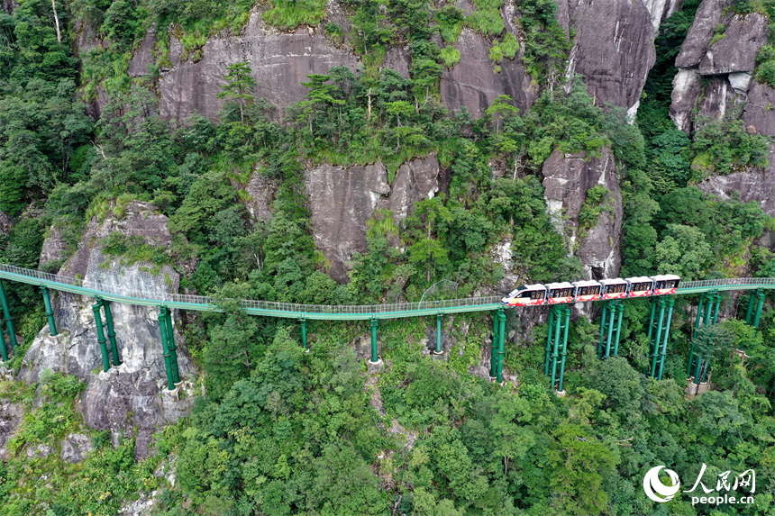 資溪縣大覺山景區，懸崖動車在綠山間穿行，游客們感受“云端飛馳”的刺激與震撼。人民網記者 時雨攝