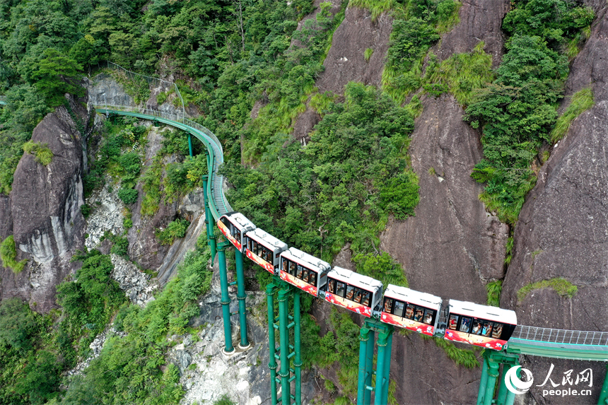 資溪縣大覺山景區，懸崖動車在綠山間穿行，游客們感受“云端飛馳”的刺激與震撼。人民網記者 時雨攝