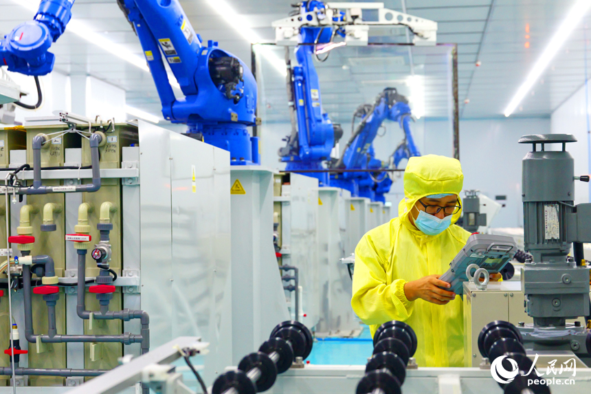 安遠縣產城新區的一家光電科技有限公司智能化生產車間內，一排排機器人揮舞著機械臂加緊作業。人民網 朱海鵬攝
