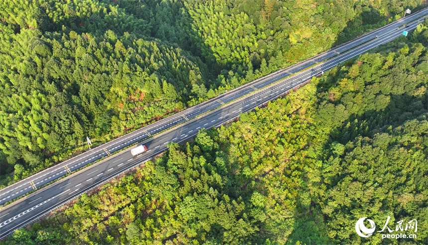 撫州市資溪縣嵩市鎮，撫（州）至吉（安）高速公路如同銀龍蜿蜒穿梭于蒼翠的崇山峻嶺間，與田園、村落相映成景。人民網 朱海鵬攝