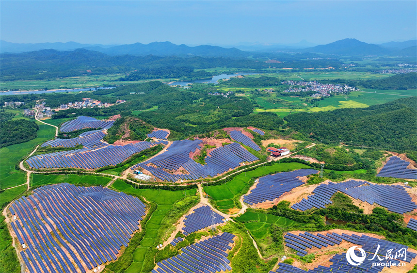 德興市香屯街道蘭村村20MW集中式光伏電站，荒山坡上的一排排光伏發電板熠熠生輝，源源不斷地輸出綠色電能。人民網 朱海鵬攝