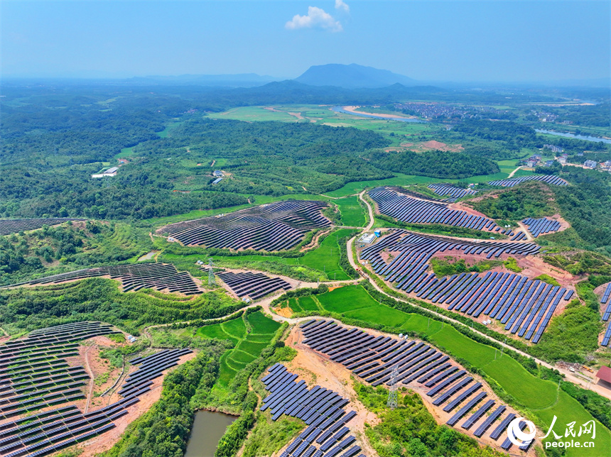 德興市香屯街道蘭村村20MW集中式光伏電站，荒山坡上的一排排光伏發電板熠熠生輝，源源不斷地輸出綠色電能。人民網 朱海鵬攝