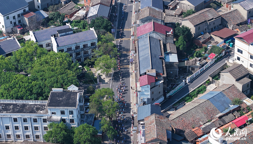 第十三屆環鄱陽湖國際自行車大賽永修站16日在永修縣吳城鎮啟航，圖為選手們在賽道競速。人民網記者 時雨攝