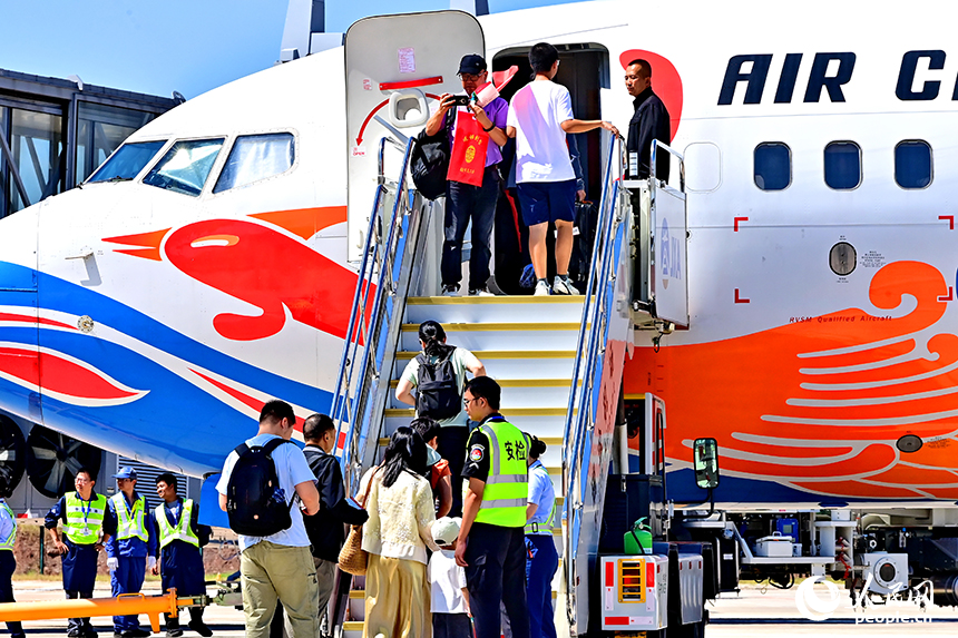 贛州瑞金機場停機坪，游客在搭乘瑞金飛往北京的CA8698航班。人民網 朱海鵬攝