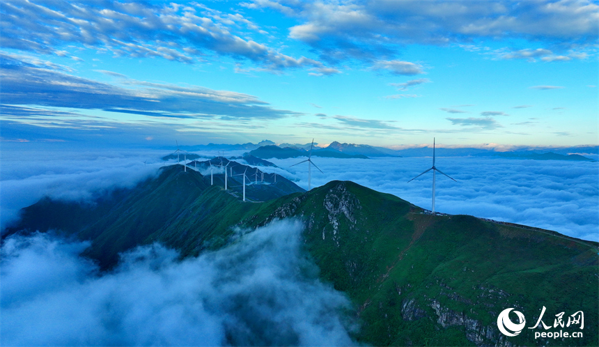 贛州市上猶縣雙溪草山云蒸霞蔚，一臺臺風力發電機迎風旋轉，與延綿群山相映成景，壯美如畫。人民網 朱海鵬攝