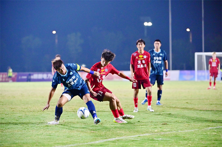 身穿紅色球員的宜春隊球員和身穿藍色球衣的景德鎮球員在綠茵場上激烈拼搶。劉勇攝