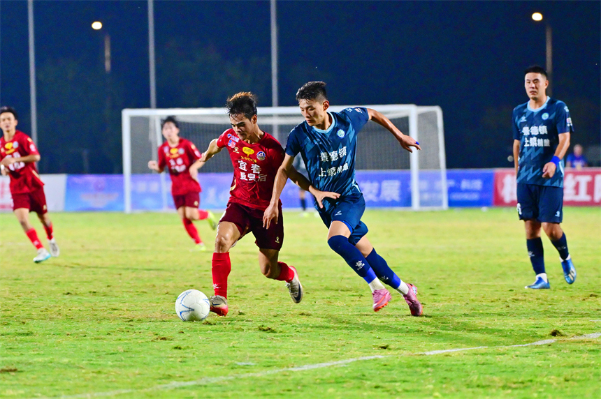 身穿紅色球員的宜春隊球員和身穿藍色球衣的景德鎮球員在綠茵場上激烈拼搶。劉勇攝