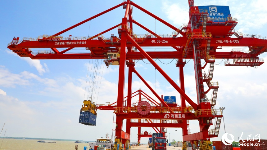 九江市彭澤縣的九江紅光國際港，碼頭貨輪穿梭，工人堅守崗位一線，集裝箱裝卸作業有序進行。人民網 朱海鵬攝