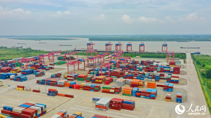 九江市彭澤縣的九江紅光國際港，碼頭貨輪穿梭，工人堅守崗位一線，集裝箱裝卸作業有序進行。人民網 朱海鵬攝