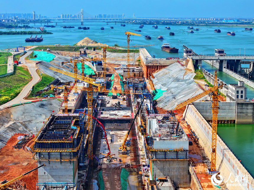 贛江龍頭山樞紐二線船閘工程建設現場塔吊林立，施工繁忙，工人在澆筑船閘主體結構。人民網 朱海鵬攝